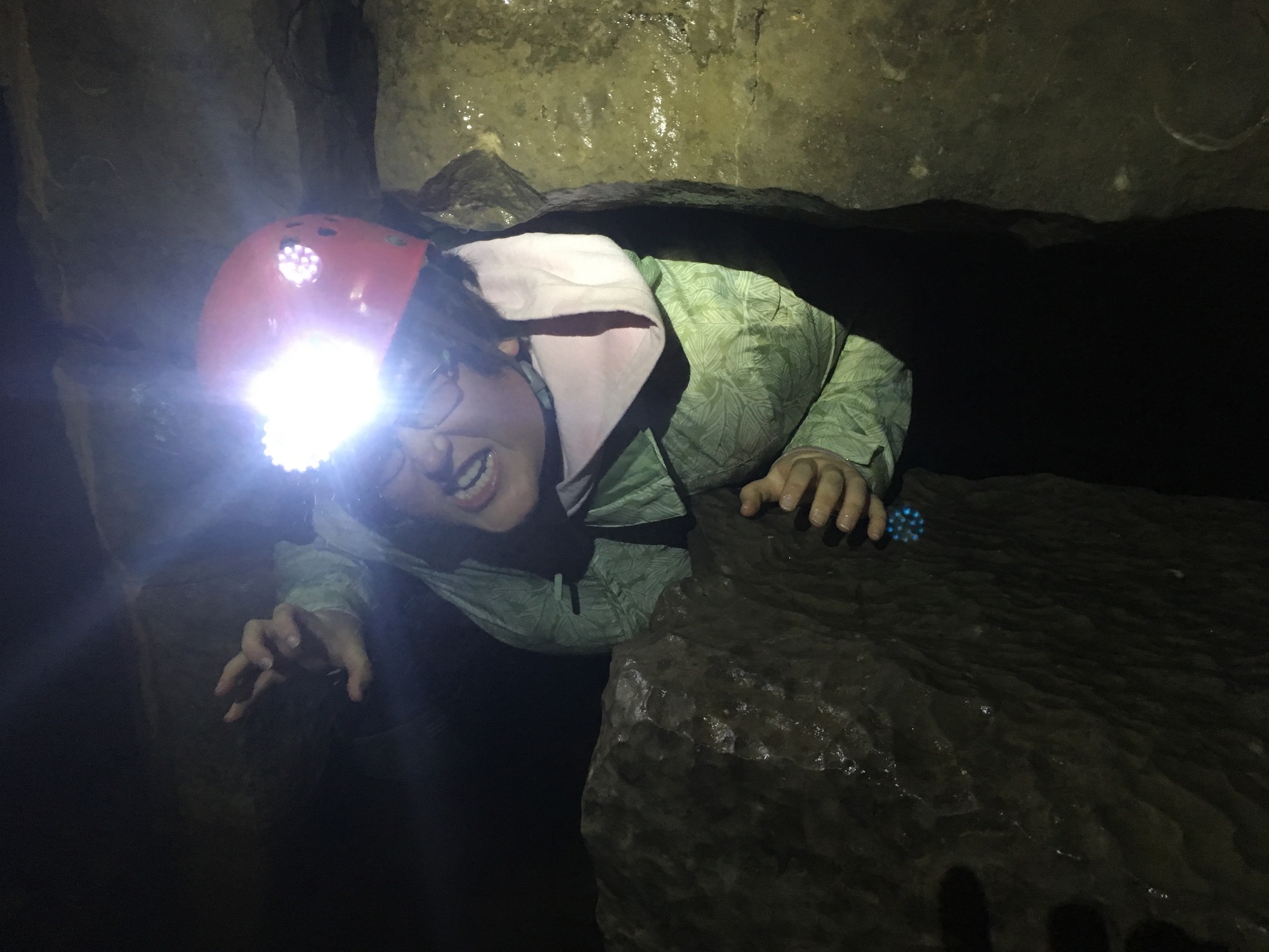 Young lady Caver appears from a hole
