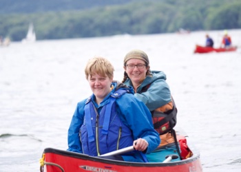 two canoeists smile at camera.
