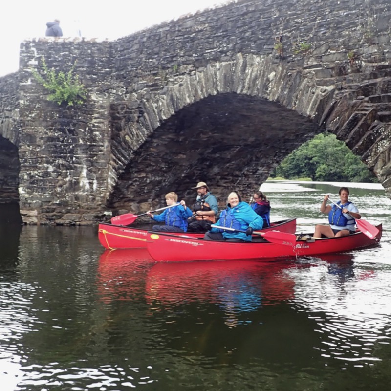 Rafted canoe under bridge