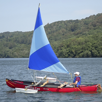 Disabled sailor sails solo next to a couple sailing.