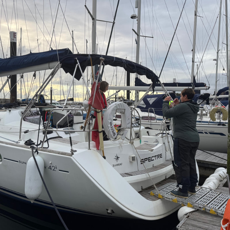 Lady smiling on hoist about to lower into cabin