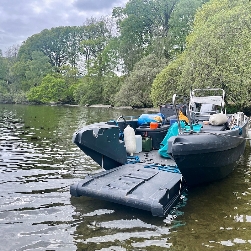 Cockpit of boat showing u shaped seating and large central wheel 