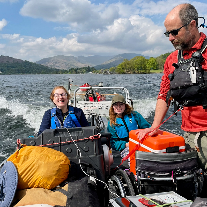 Cockpit of boat showing u shaped seating and large central wheel 