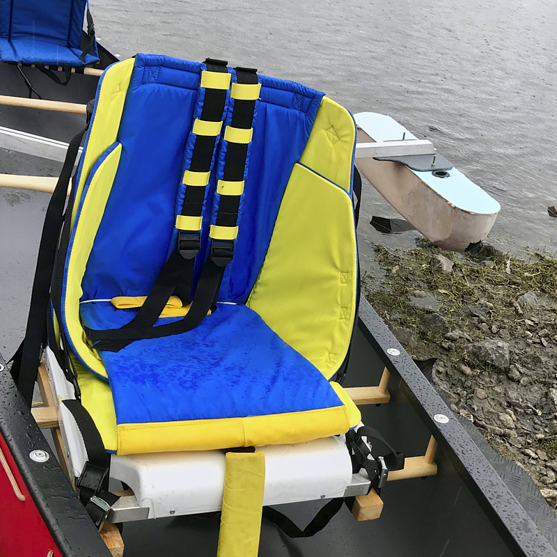 Cockpit of boat showing u shaped seating and large central wheel 