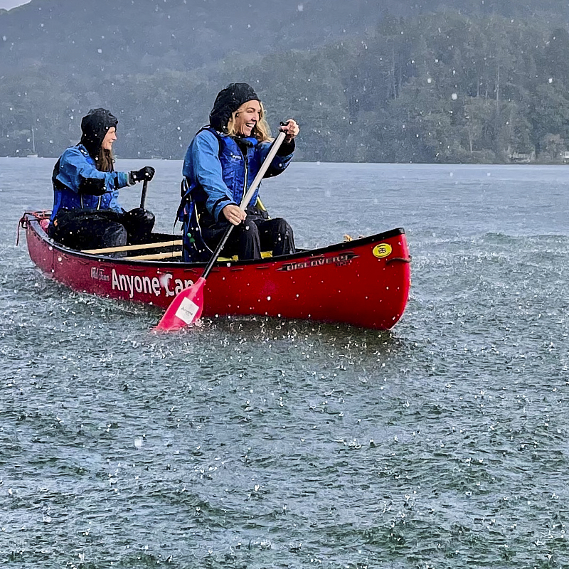 Cockpit of boat showing u shaped seating and large central wheel 