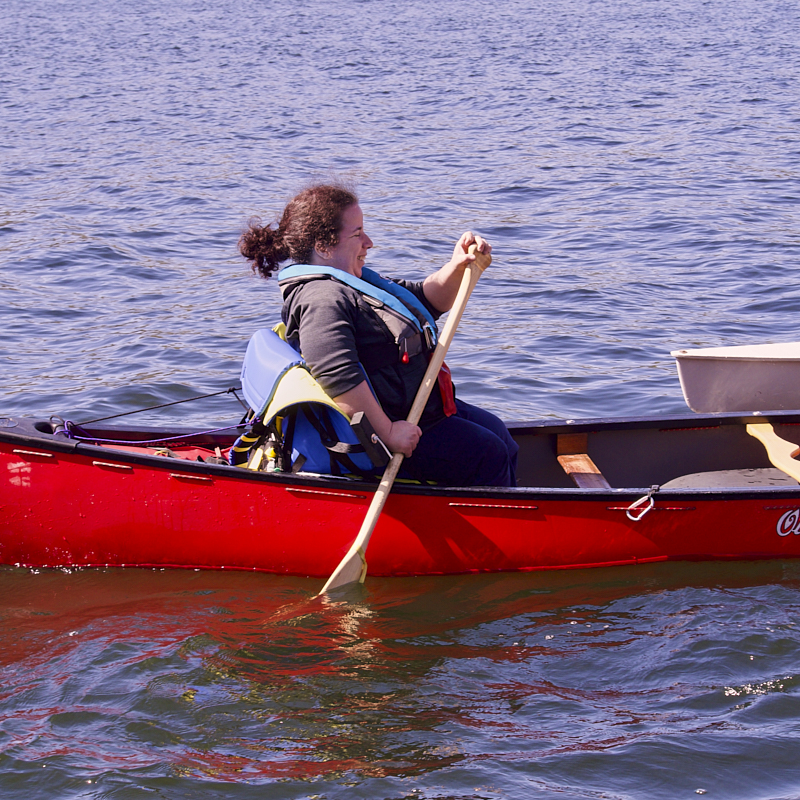 Cockpit of boat showing u shaped seating and large central wheel 