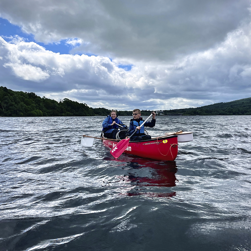Cockpit of boat showing u shaped seating and large central wheel 
