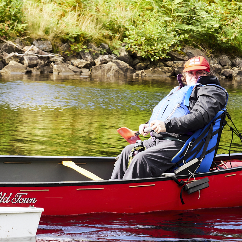 Cockpit of boat showing u shaped seating and large central wheel 