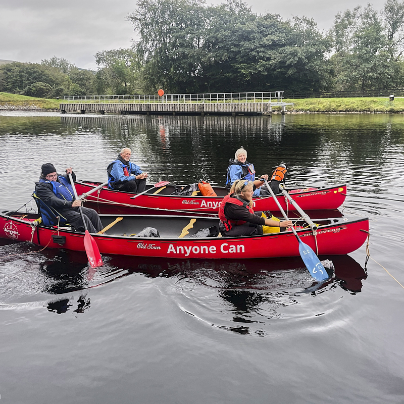 Cockpit of boat showing u shaped seating and large central wheel 