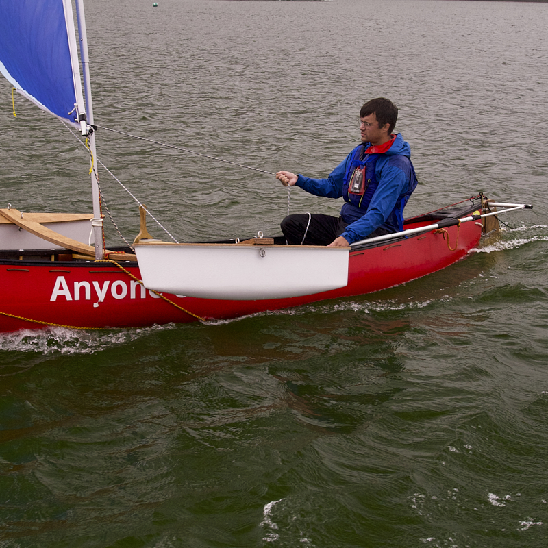 Cockpit of boat showing u shaped seating and large central wheel 