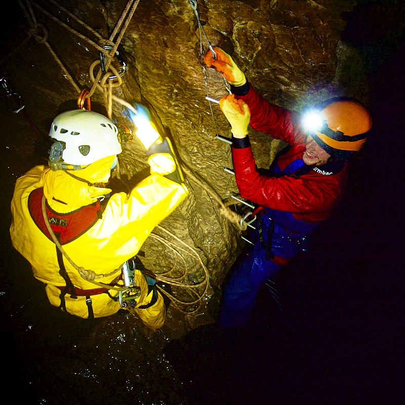 instructor gets ready to help clinet abseil