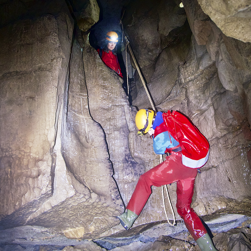 Caver abseils from underground balcony