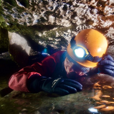 Caver crawls through a tight space