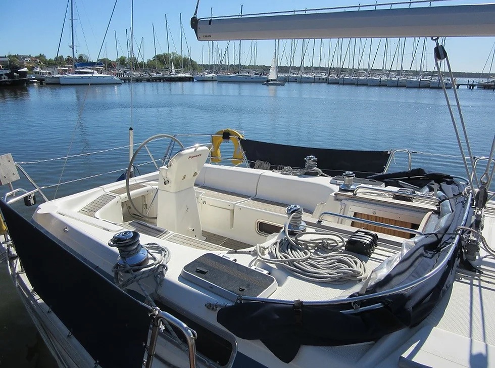 Cockpit of boat showing u shaped seating and large central wheel 