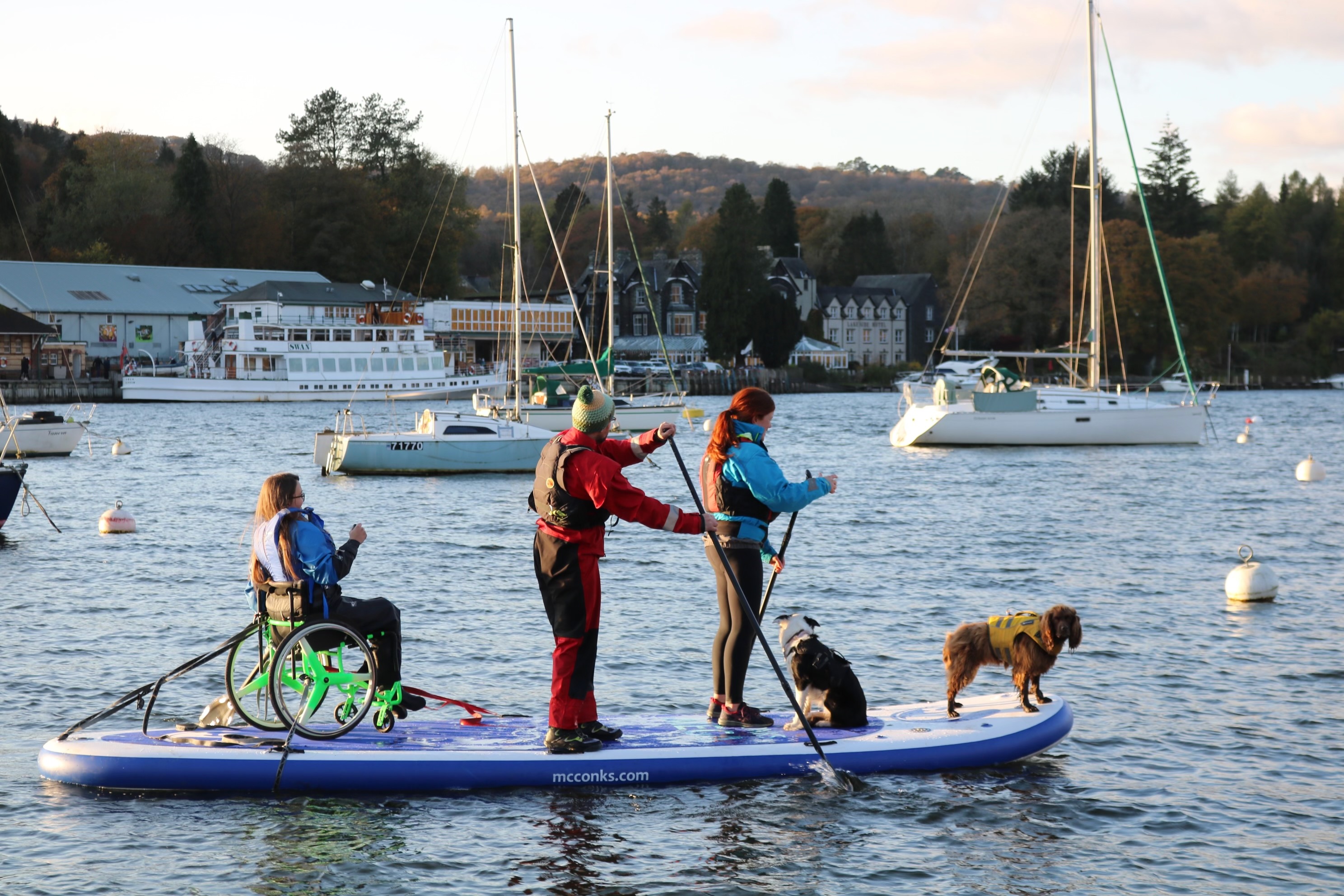 Green yacht surges under red sails